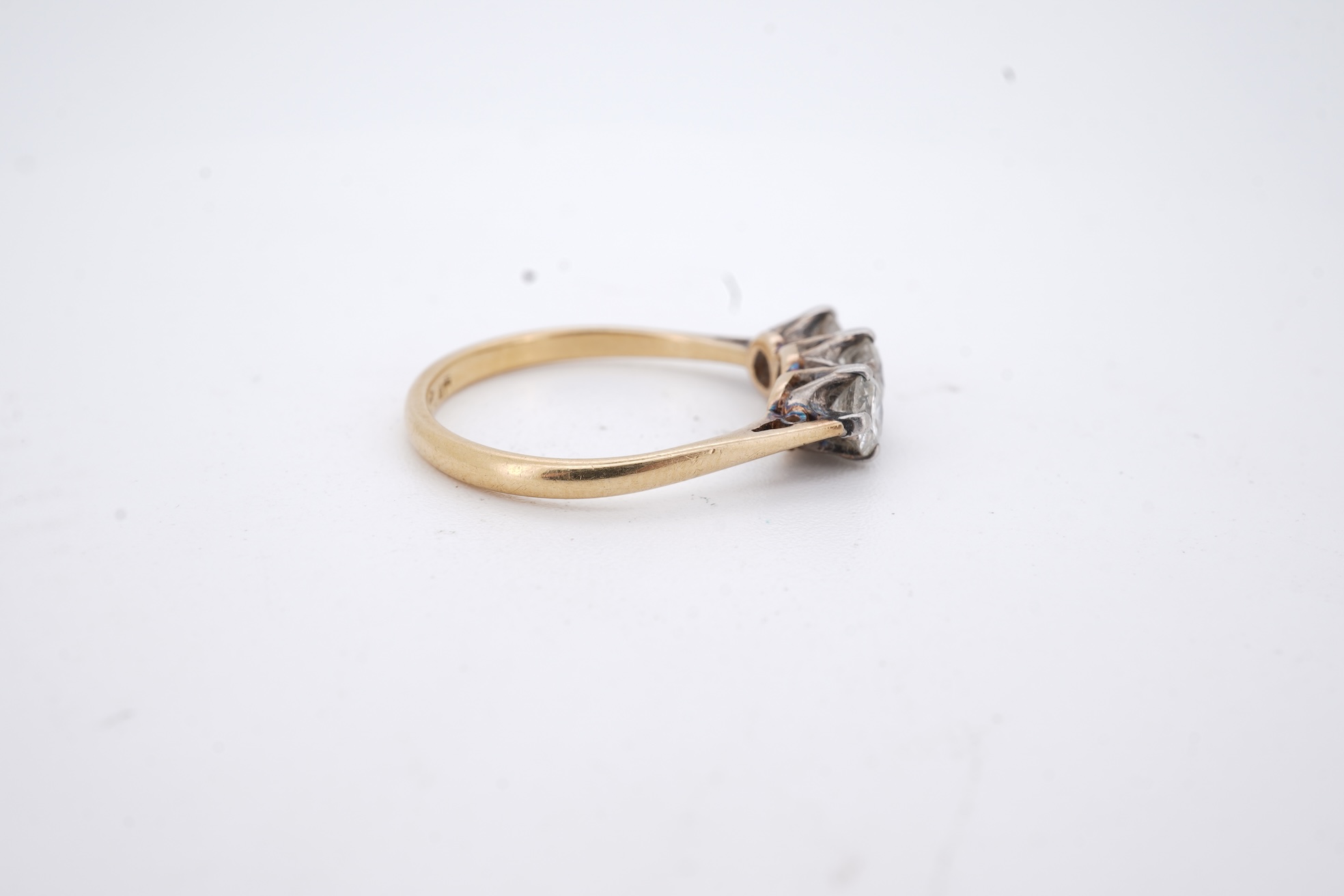 A yellow metal (stamped 18ct, & plat) and three stone diamond set ring, size L, gross weight 2.1 grams.